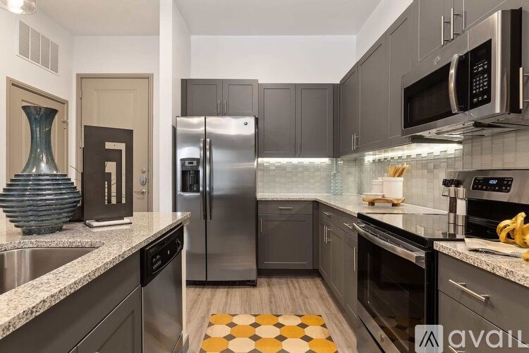 A kitchen with a black fridge and a black microwave.