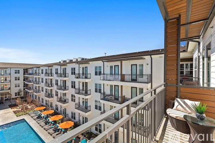 A sunny day at the poolside of a multi-story apartment building.