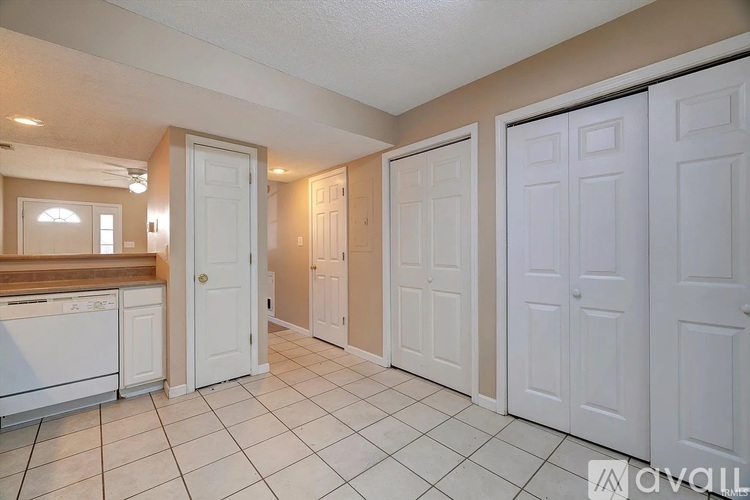 A kitchen with white cabinets and a washer and dryer.