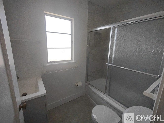 A bathroom with a toilet, sink, and shower.