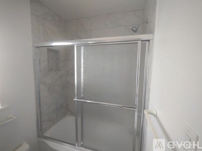 A shower stall with a glass door and a metal frame.