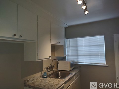 A kitchen with white cabinets and a granite countertop.