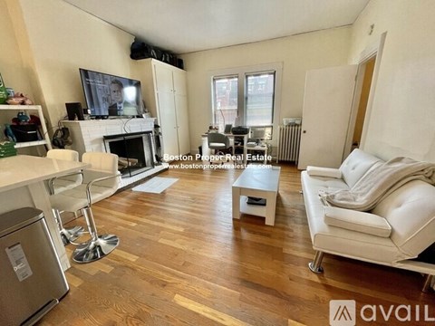 A living room with a fireplace and a television on the wall.