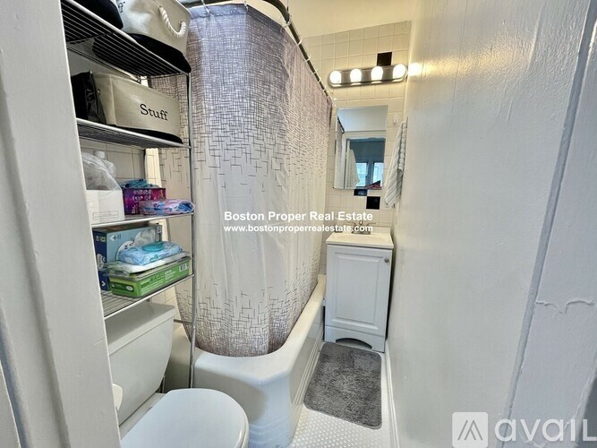 A small bathroom with a toilet, sink, and shower.