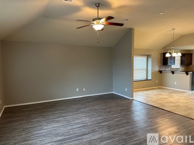 A room with a chandelier, tiled floor, and a window with blinds.