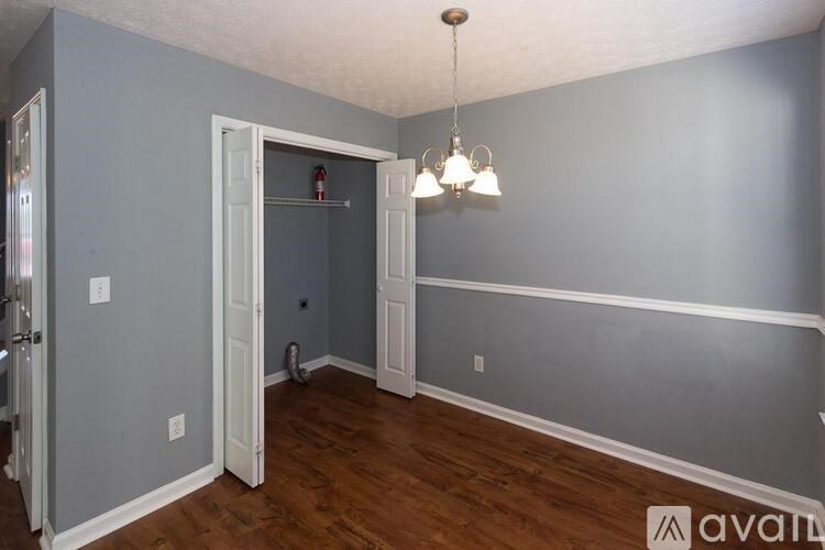 A room with a grey wall and wooden floor.