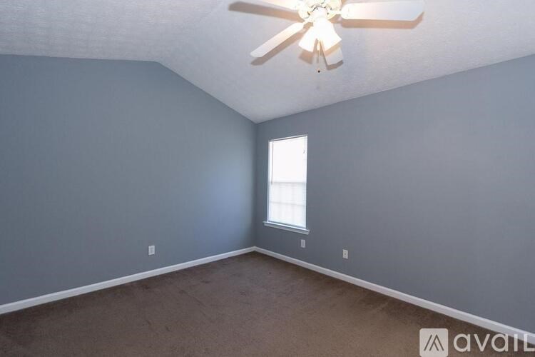 A room with a ceiling fan and a window.