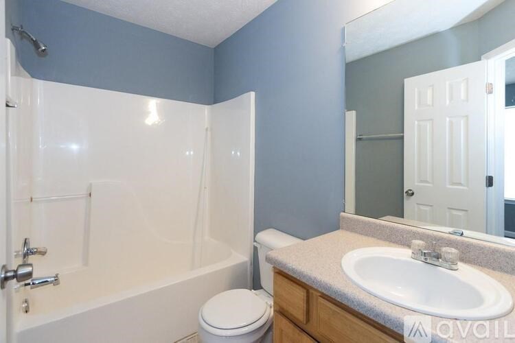 A bathroom with a white tub, toilet, and sink.