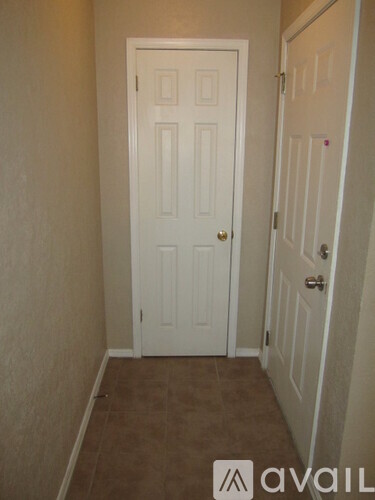 A white door is in a room with carpeted flooring.