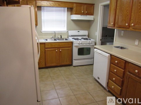 A kitchen with wooden cabinets and a white refrigerator.