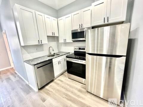 A kitchen with white cabinets and stainless steel appliances.