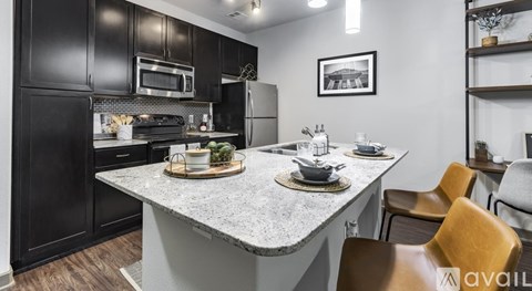 A kitchen with a table set for two and chairs around it.