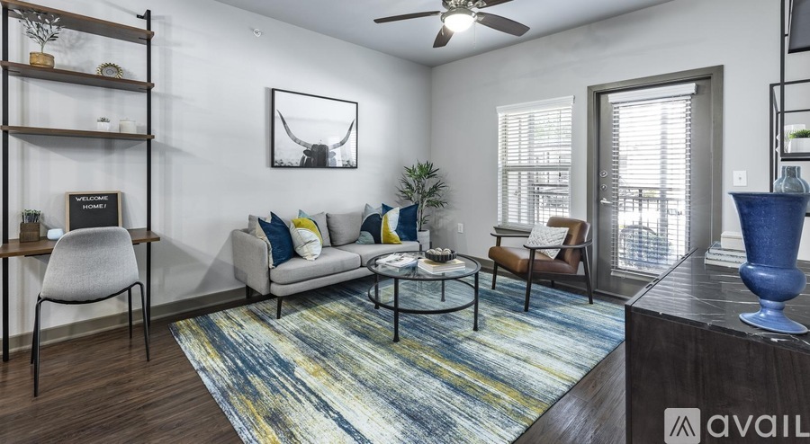 A living room with a sofa, chairs, and a rug.