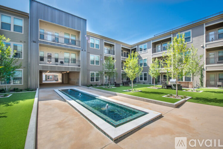A modern apartment complex with a pool in the courtyard.