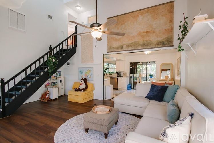 A living room with a white couch and a yellow chair.