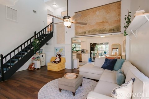 A living room with a white couch and a yellow chair.
