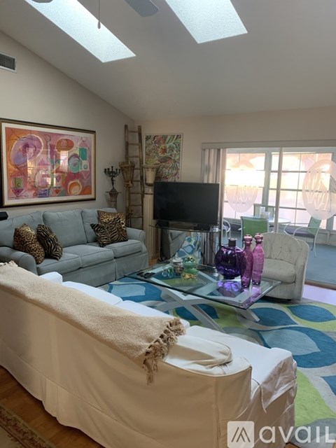 A living room with a grey couch and a white chair.