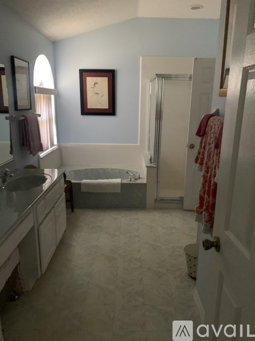 A bathroom with a tub, sink, and towel rack.