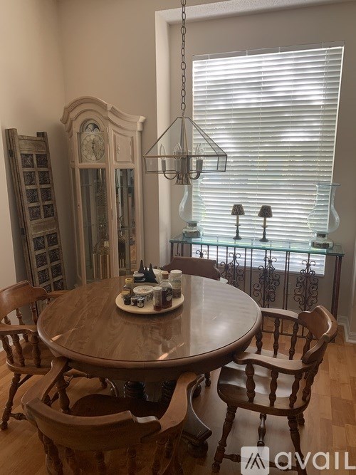 A dining room with a round wooden table and chairs.