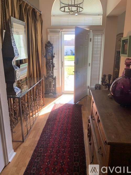 A hallway with a red carpet and a glass display case.