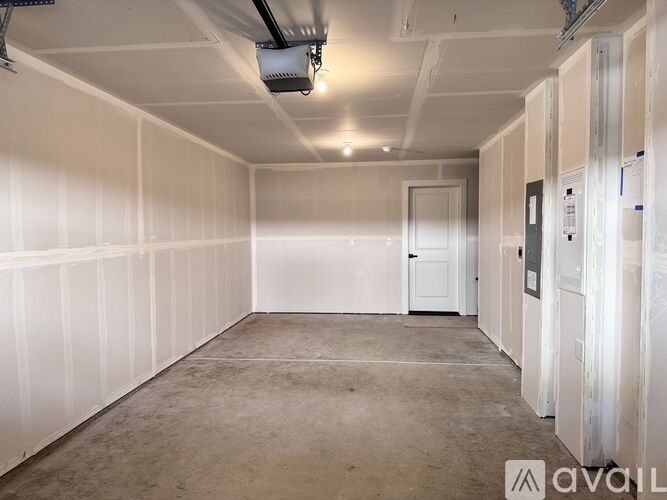 A large empty room with white walls and a concrete floor.