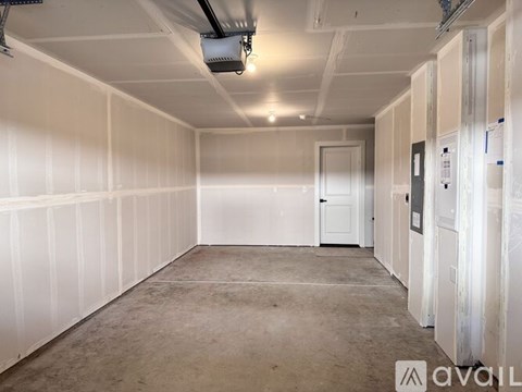 A large empty room with white walls and a concrete floor.