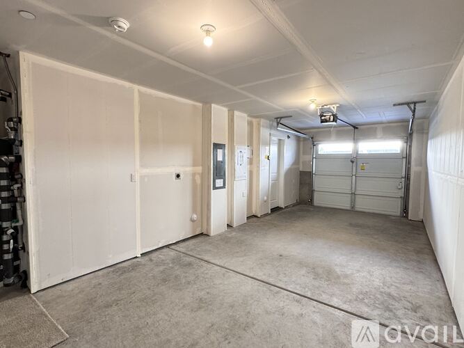 A spacious garage with white walls and a concrete floor.