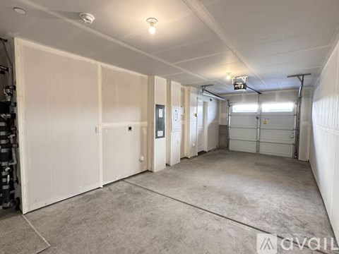 A spacious garage with white walls and a concrete floor.