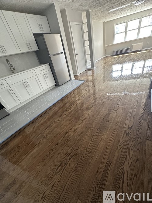 A kitchen with white cabinets and a wooden floor.