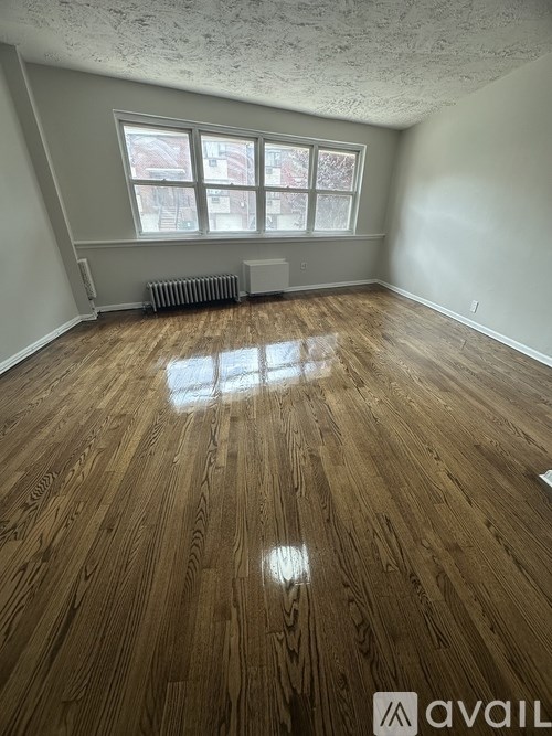 A room with wooden flooring and a window.