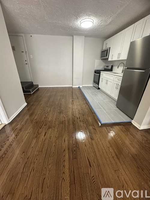 A kitchen with wooden floors and white cabinets.