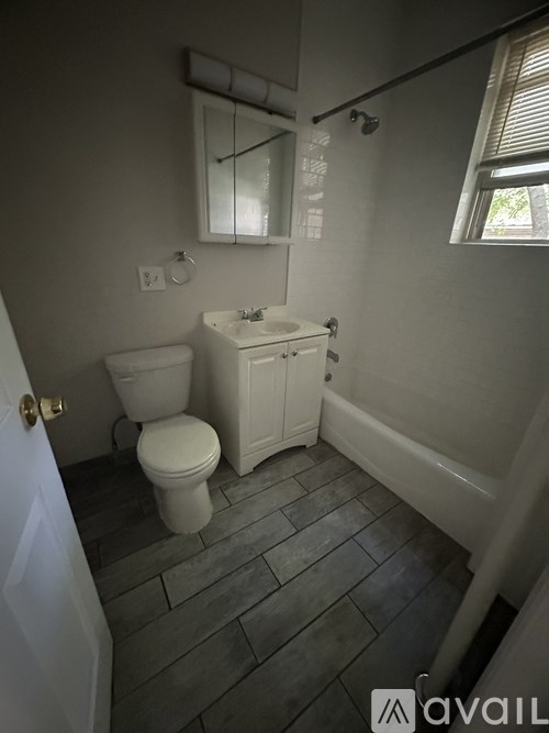 A bathroom with a toilet, sink, and bathtub.