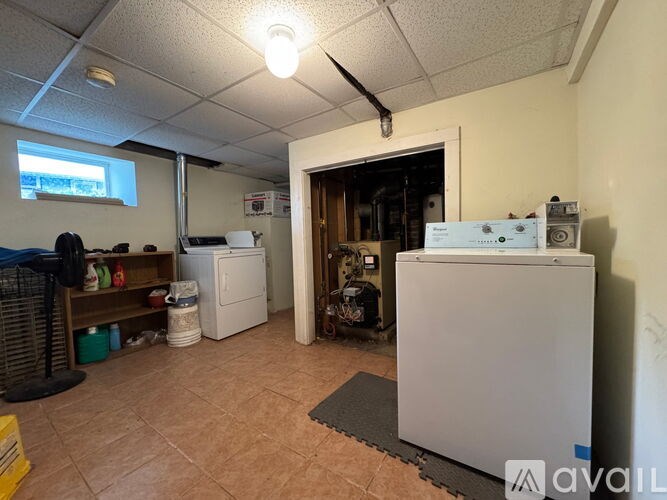A room with a white refrigerator, a white cabinet, and a white box on the floor.