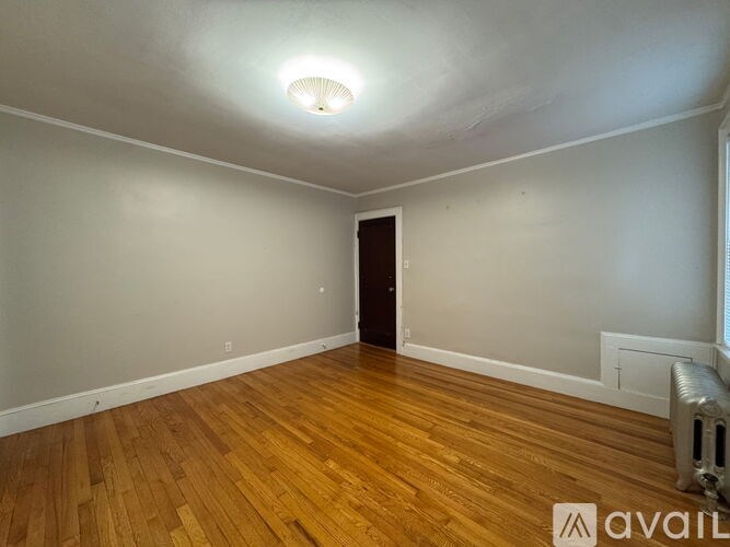 A room with wooden floors and a ceiling light.