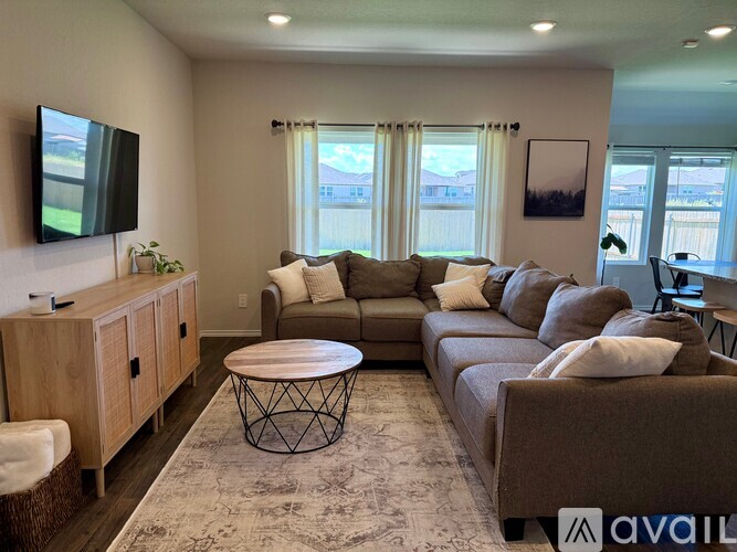 A living room with a large couch, a TV, and a coffee table.