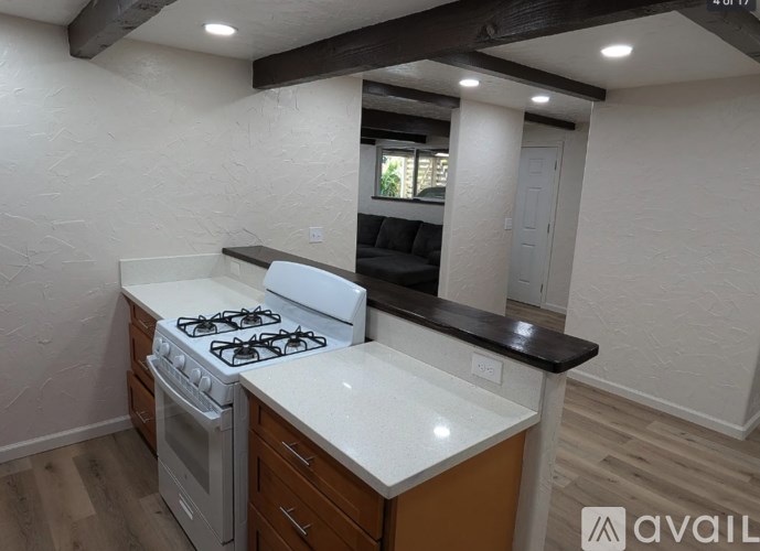 A kitchen with a white countertop and a white stove top oven.
