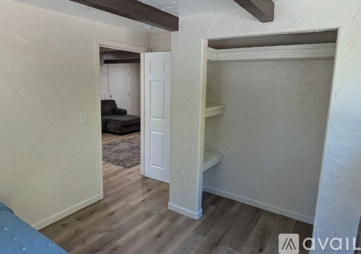 A room with a white door and a white shelf.