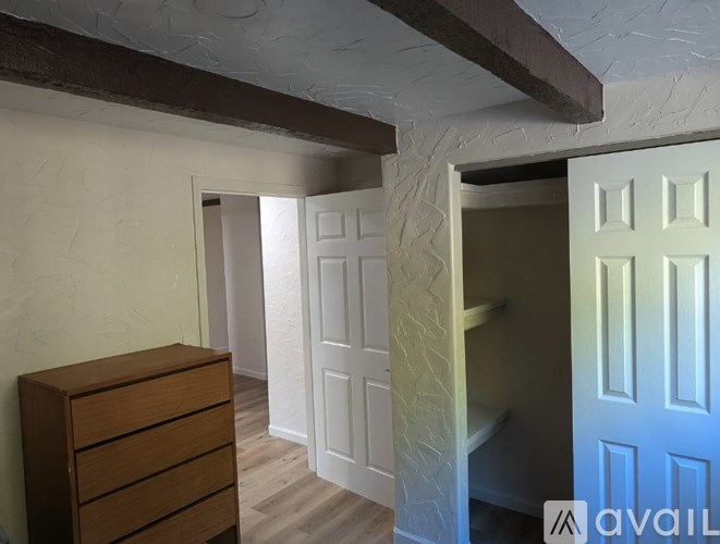 A room with a wooden dresser and a white door.