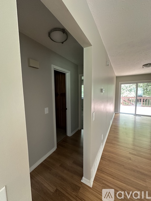 A hallway with wood floors and white walls.