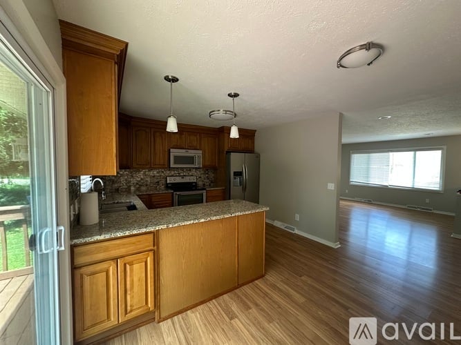 A kitchen with wooden cabinets and a granite countertop.