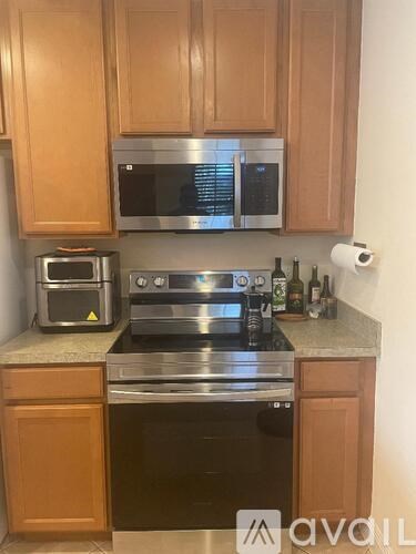 A kitchen with wooden cabinets and a stainless steel oven.