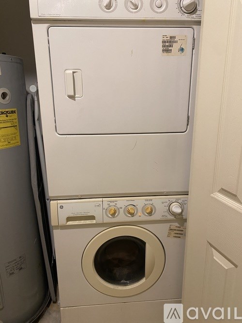 A white dryer and washer are stacked on top of each other.