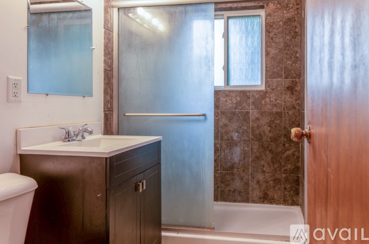 A bathroom with a toilet, sink, and shower.