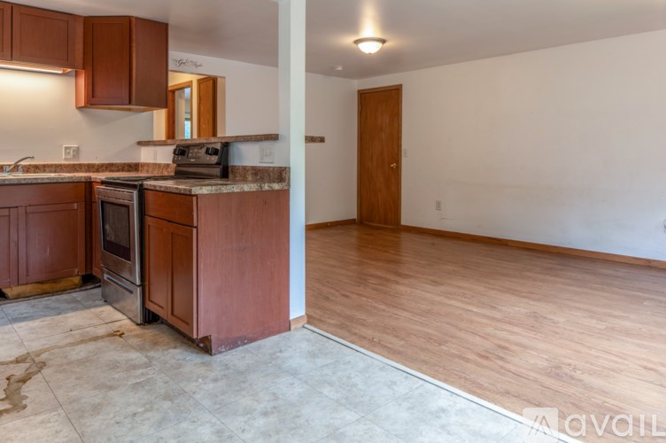 A kitchen with wooden cabinets and a marble countertop.