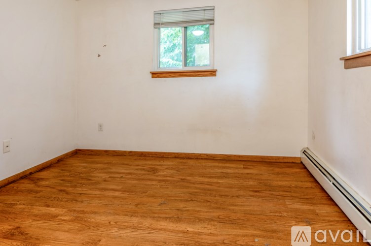 A room with wooden flooring and a window.