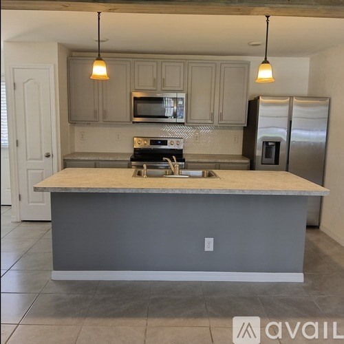 A kitchen with a granite countertop and stainless steel appliances.