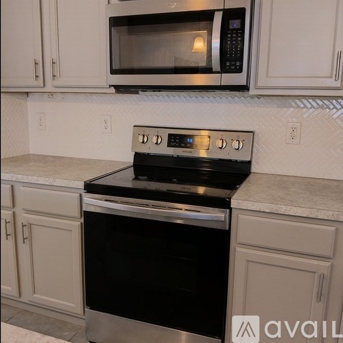 A black stove top oven with four burners and a microwave above it.