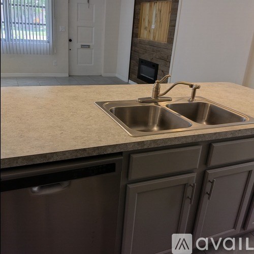 A kitchen with a granite countertop and a double sink.