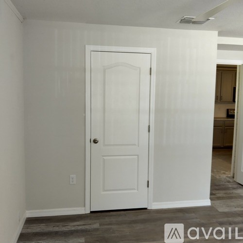 A white door is in a room with a carpeted floor.