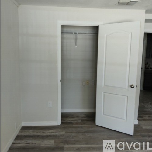 A white door is open to a room with a window.